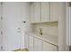 Well lit hallway with white cabinets, countertop and a door to the exterior at 11037 Clarion Ln, Las Vegas, NV 89134