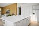 Bright, expansive kitchen with white cabinetry, marble countertops, an eat-in island, and modern appliances at 11037 Clarion Ln, Las Vegas, NV 89134