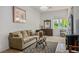 Cozy living room with tile flooring, neutral-colored sofa, area rug, and bright window at 11037 Clarion Ln, Las Vegas, NV 89134