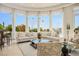 Bright and open living room with large windows, neutral furniture, bar and backyard pool view at 11037 Clarion Ln, Las Vegas, NV 89134
