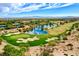 Expansive aerial view of a golf course and community amenities including water features and lush greenery in a desert setting at 11573 Glowing Sunset Ln, Las Vegas, NV 89135