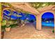 Inviting back patio with pergola, outdoor kitchen, and a sparkling pool at twilight at 11573 Glowing Sunset Ln, Las Vegas, NV 89135
