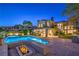 Spacious backyard with a sparkling pool, spa, and fire pit, perfect for outdoor relaxation and entertaining guests at 11573 Glowing Sunset Ln, Las Vegas, NV 89135
