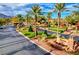 Landscaped entrance to West Gate private community with palm trees and well-maintained greenery at 11573 Glowing Sunset Ln, Las Vegas, NV 89135
