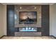 Close-up of fireplace with stone surround, integrated entertainment center, and contemporary design at 11573 Glowing Sunset Ln, Las Vegas, NV 89135