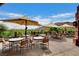Outdoor patio seating area with umbrellas and mountain views, perfect for relaxing or entertaining at 11573 Glowing Sunset Ln, Las Vegas, NV 89135