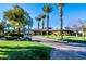 Scenic street view of a home with lush landscaping, mature palm trees and decorative driveway at 11573 Glowing Sunset Ln, Las Vegas, NV 89135