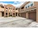 This exterior shows off the garages and stucco facade of this condo complex at 11870 Tevare Ln # 1085, Las Vegas, NV 89138