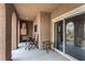 Covered patio with outdoor seating and a sliding glass door entrance to the house at 11870 Tevare Ln # 1085, Las Vegas, NV 89138