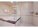 Luxurious bathroom featuring a soaking tub, glass shower, and neutral tile at 135 E Harmon Ave # 3215, Las Vegas, NV 89109