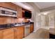 Efficient kitchenette featuring wooden cabinets, microwave, refrigerator, and a sleek countertop with built-in television at 135 E Harmon Ave # 3215, Las Vegas, NV 89109