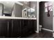 Modern bathroom featuring dual sinks, dark cabinetry, and wood-look flooring at 1766 Molly Meadows St, Las Vegas, NV 89115