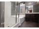 Bathroom featuring glass enclosed shower, soaking tub, and dark cabinetry at 1766 Molly Meadows St, Las Vegas, NV 89115