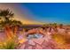Scenic backyard showcasing rock features, waterfall, beautiful desert landscaping, and distant views at 1779 Sebring Hills Dr, Henderson, NV 89052