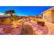 Lush backyard with waterfall feature, manicured trees and desert views at sunset at 1779 Sebring Hills Dr, Henderson, NV 89052