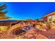Backyard water feature with rock landscaping and mature trees, all set against mountain views at 1779 Sebring Hills Dr, Henderson, NV 89052