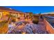 Beautiful backyard landscaping featuring a rock waterfall, mature palm trees, and desert shrubs at 1779 Sebring Hills Dr, Henderson, NV 89052