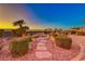 Serene backyard with a charming water feature, stone pavers, and manicured landscaping at 1779 Sebring Hills Dr, Henderson, NV 89052
