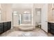 Elegant bathroom with dual vanities, bathtub, and glass-enclosed shower at 1779 Sebring Hills Dr, Henderson, NV 89052