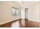 Well-lit bedroom with hardwood floors, a closet, and a window showcasing yard greenery at 1779 Sebring Hills Dr, Henderson, NV 89052