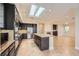 Modern kitchen featuring dark cabinets, stainless steel appliances, granite countertops, and skylight at 1779 Sebring Hills Dr, Henderson, NV 89052