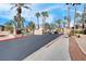 Community entrance with palm trees, stone walls, and well-maintained landscaping under a sunny sky at 1830 N Buffalo Dr # 2043, Las Vegas, NV 89128