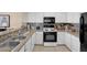 Bright kitchen with white cabinetry, stainless steel appliances and ample counter space at 1830 N Buffalo Dr # 2043, Las Vegas, NV 89128