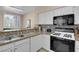 Modern kitchen featuring white cabinets, granite countertops, and stainless steel appliances at 1830 N Buffalo Dr # 2043, Las Vegas, NV 89128