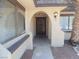 Arched doorway with dark wood door between two windows and a desert landscaped yard at 230 Queen Marie Ct, Henderson, NV 89015