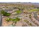 Stunning aerial view of the golf course, pools, and surrounding neighborhood with beautiful desert mountains in the background at 2585 Shellsburg Ave, Henderson, NV 89052