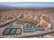 A wonderful aerial showcasing a vibrant community, pool, tennis and bocce ball courts surrounded by mountains and city skyline at 2585 Shellsburg Ave, Henderson, NV 89052