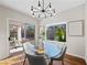 Elegant dining area featuring a glass table, modern chandelier, and seamless access to the outdoor patio at 2585 Shellsburg Ave, Henderson, NV 89052