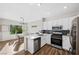 Open-concept kitchen with white cabinetry, stainless steel appliances, and dining area at 2585 Shellsburg Ave, Henderson, NV 89052