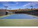 Outdoor tennis court featuring a blue and green surface, benches, and shaded area for players to relax between sets at 2585 Shellsburg Ave, Henderson, NV 89052