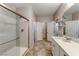 Modern bathroom with glass shower, tiled floors, double sink vanity, and adjacent closet with shelving, for convenience at 2767 Flowing Breeze St, Henderson, NV 89044