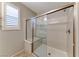Shower boasting glass door, a tiled floor, a built-in seat, and a shuttered window, offering both style and comfort at 2767 Flowing Breeze St, Henderson, NV 89044
