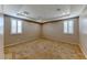 Inviting carpeted bedroom filled with natural light showcases tray ceiling, shuttered windows and neutral color scheme at 2767 Flowing Breeze St, Henderson, NV 89044