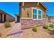 Exterior of a single story home with stone accents, desert landscaping, and a paved walkway to the front door at 2767 Flowing Breeze St, Henderson, NV 89044