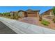 Charming single-story house featuring a brick driveway, desert landscaping, and an attached two-car garage at 2767 Flowing Breeze St, Henderson, NV 89044