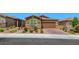 Single-story home with a well-maintained front yard, desert landscaping, a brick driveway and an attached garage at 2767 Flowing Breeze St, Henderson, NV 89044