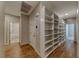 Hallway with wood floors, built-in storage shelves, and doorways to a bathroom and bedroom at 2767 Flowing Breeze St, Henderson, NV 89044