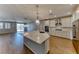 Open kitchen with stainless steel appliances, large island, and hardwood floors flowing into the living area at 2767 Flowing Breeze St, Henderson, NV 89044