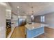 Modern kitchen with white cabinets, stainless steel appliances, and a large island with marble countertop at 2767 Flowing Breeze St, Henderson, NV 89044