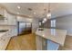 Elegant kitchen with stainless steel refrigerator, white cabinets, and a spacious island with seating at 2767 Flowing Breeze St, Henderson, NV 89044