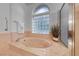 Elegant bathroom with a luxurious soaking tub, glass block window, and neutral tones at 2850 Thunder Bay Ave, Henderson, NV 89052