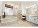Bright bathroom features a soaking tub, glass-enclosed shower, and white cabinetry at 2859 Hayden Creek Ter, Henderson, NV 89052