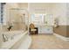 Bright bathroom features a soaking tub, glass-enclosed shower, and white cabinetry at 2859 Hayden Creek Ter, Henderson, NV 89052