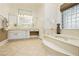 Bright bathroom features a soaking tub, glass-enclosed shower, and white cabinetry at 2859 Hayden Creek Ter, Henderson, NV 89052