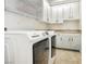 Bright laundry room with white cabinets, shelving, and modern washer and dryer at 2859 Hayden Creek Ter, Henderson, NV 89052