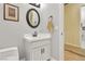 This powder room features a white vanity, round mirror, and neutral paint at 2859 Hayden Creek Ter, Henderson, NV 89052